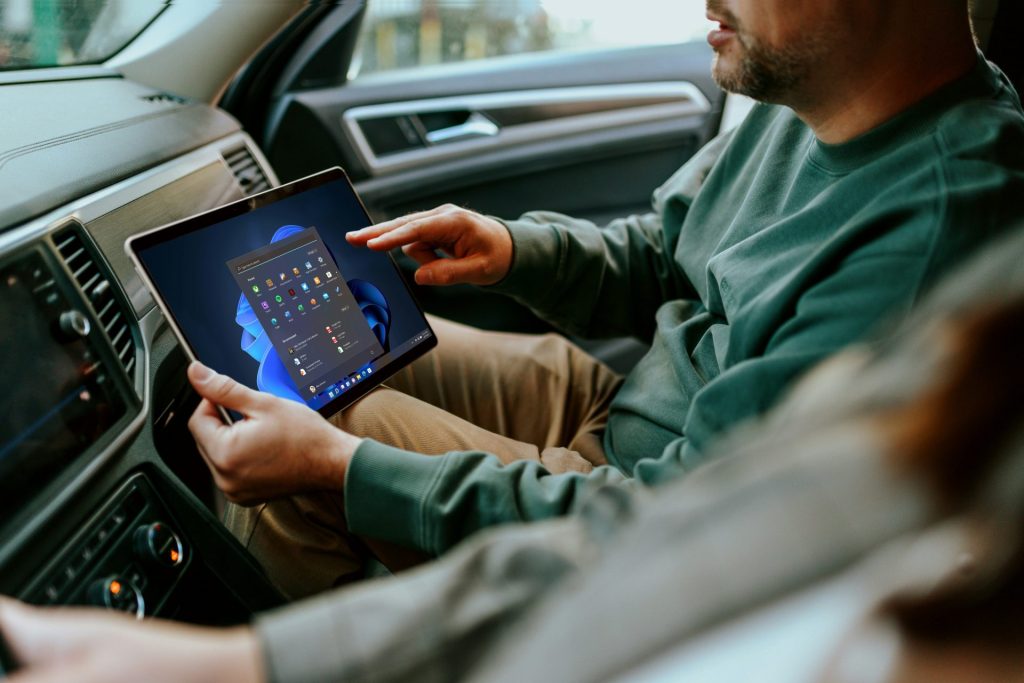 un homme assis dans une voiture tenant une tablette